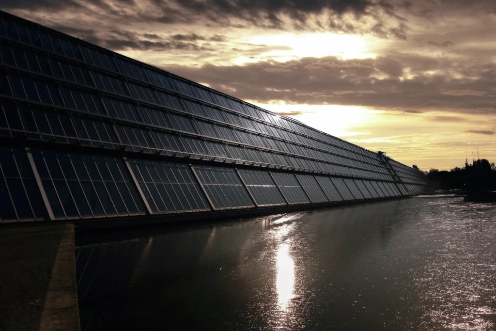 solar panels on the side of a building next to a waterway illustrating the point of the article: Is Solar Worth the Hype?